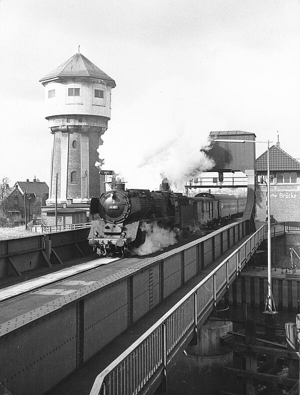 Dampflok fährt über die Rollklappbrücke, im Hintergrund der Wasserturm, 1965, Foto: Stadtmuseum Oldenburg/Dreyhaupt