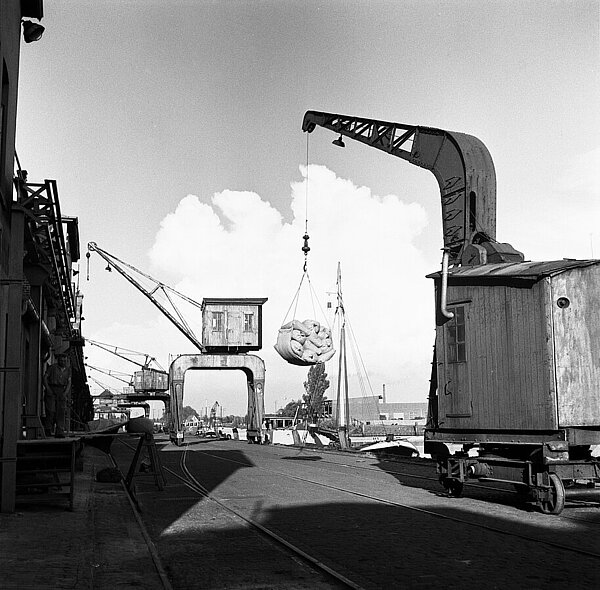 Alter Hafenkran im Einsatz: Über den Haken am Ausleger werden Güter verladen, um 1960, Foto: Stadtmuseum Oldenburg