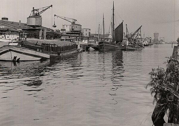 Warenumschlag und Lagerhallen am Hafen. Im Hintergrund ist der Wasserturm zu sehen (um 1960). Foto: Stadtmuseum Oldenburg/Günter Nordhausen