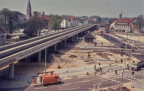 Die neue Verkehrsführung für die Bahnhochlegung im Mitte der 1960er Jahre. Links im Hintergrund die Peterskirche, rechts am Horizont die alte Fleiwa. Foto: Stadtmuseum Oldenburg/Willy Schröder.