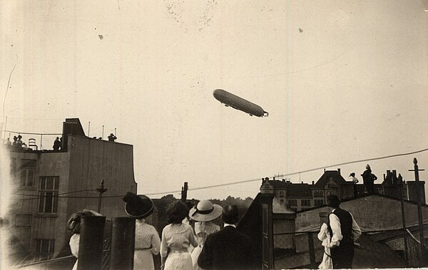 Oldenburger:innen stehen auf den Dächern ihrer Wohnhäuser, um den Flug des Zeppelins über die Stadt zu beobachten, 1912. Bild: Stadtmuseum Oldenburg.
